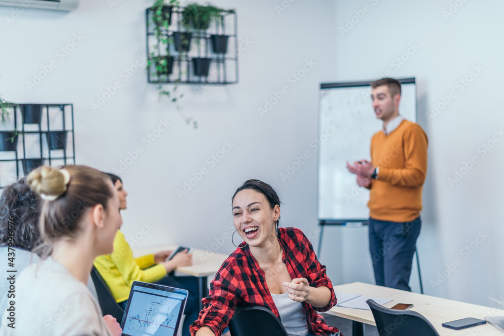 Wall mural  Multi-ethnic business group listening to a speaker while attending a business seminar at a modern workshop...