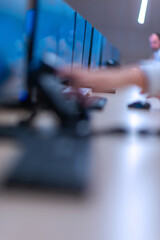 Group of Security data center operators (administrators) working in a group at a CCTV monitoring room while looking at multiple monitors ( computer screens)