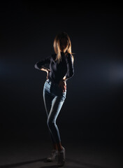 Silhouette picture of a young gorgeous woman posing on black background