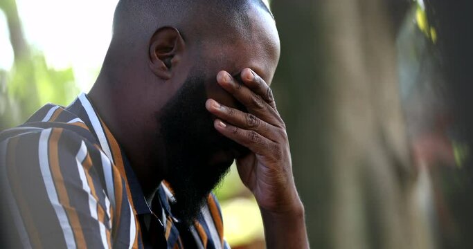 Worried man praying to God during difficult times, frustrated person feeling regret