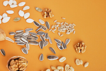 a handful of different nuts and seeds on a brown background