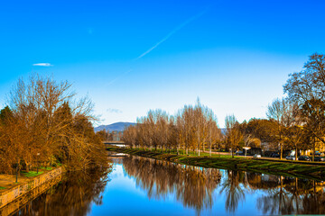River reflecting ambience with trees and blue sky 