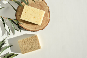 Eco-friendly dish sponges on a wooden catwalk with natural shadows