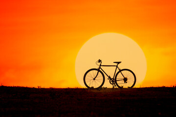 Silhouette of a bicycle with big sun