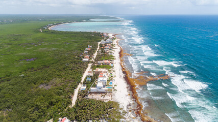 Top-down drone view over beachfront hotels of the Caribbean in Tulum, Mexico.