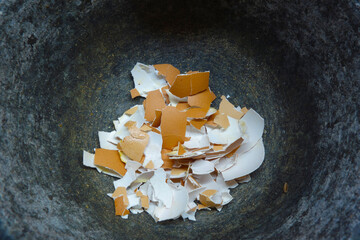 Crushed eggshells in a mortar made of massive natural granite
