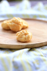 Choux cream, small fluffy creamy yummy vanilla inserted in round dessert as cold fresh sweet on wood plate.