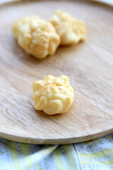 Choux cream, small fluffy creamy yummy vanilla inserted in round dessert as cold fresh sweet on wood plate.