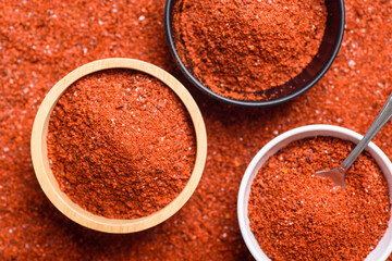 Red cayenne pepper, Chili flakes, Chili powder in a bowl with spoon, Top view