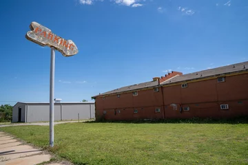 Fototapete Route 66 Old rusty generic parking sign with an arrow points to a grassy field  © MelissaMN