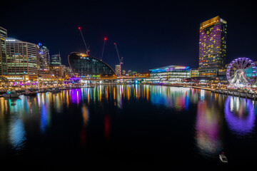 Panoramic night view of Sydney Harbour and City Skyline of Darling Harbour and Barangaroo Australia bright neon lights reflecting off the water