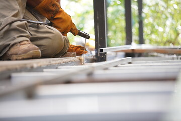 Engieer safety for welding and hard ware working in plant for line production lines.  Yellow Steel welding safety gloves on long iron bars on floor for building in constraction.