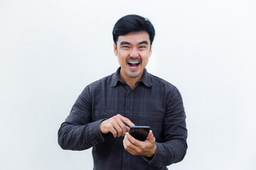 adult asian man using mobile, cell phone.young male person.posing smiling laughing look excited surprised thinking positive happy.empty,copy space for text advertising.white background