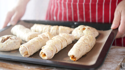 Whole wheat bread from homemade whole grain dough made by woman with red apron. Healthy pastry with many grains.