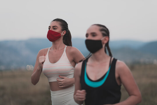 Three Multiethnic Women Runners Group Wear Face Masks Running Keep Social Distance Outdoor. Fit Healthy Diverse Team Wear Sportswear Jogging In Park On Nature Sport Track Distancing For Safety.