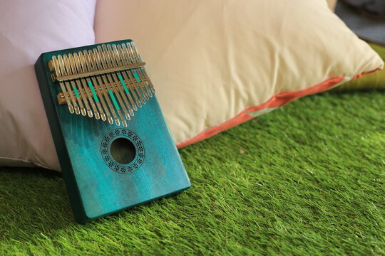 Kalimba or mbira is an African musical instrument.Traditional small Kalimba made from  wooden board with metal, play on  hands and plucking the tines with the thumbs. Instrument in room