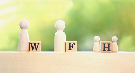 Work from home or initial is  W F H  word on wooden block on blue cloth with green light bokeh...