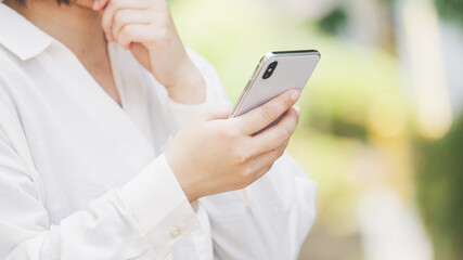 スマホを使う女性・新緑