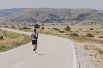 Obraz premium Young man and woman in protective masks running and doing exercises outdoors in the morning. Sport, Active life Jogging during quarantine. Covid-19 new normal. High quality photo. Selective focus.