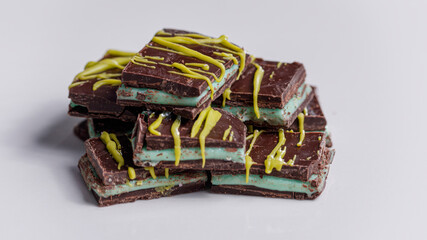 Close up of dark milk chocolate filled with mint, on a light gray background.