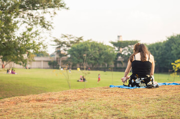 Young girl seated and reading a book in a park