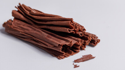 dark chocolate in the shape of a branch on a light gray background