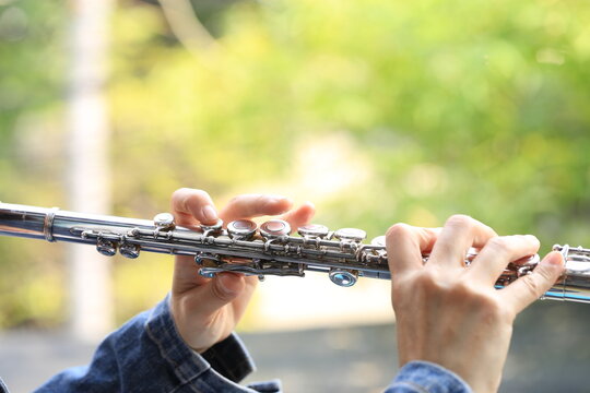 Flute Classical Instrument Player Playing Song. Instructor Practicing Bronze Woodwind For Orchestra As Solo With Green Bokeh Outside With Nature.