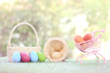 Baby cute and adorable rabbit sitting on green grass. Small and young bunny  is a lovely furry pet.  Easter concept on yellow background, egg and grass with bokeh as nature background