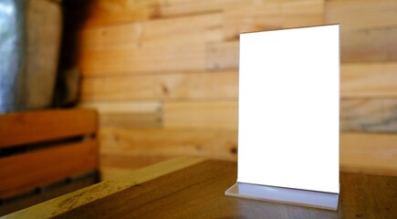 Mock up Menu frame standing on wood table in Bar restaurant cafe. space for text.