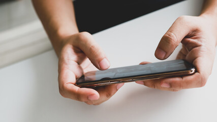 Man playing game on mobile phone. gamer boy playing video games holding Smartphone working mobile devices. cell telephone technology e-commerce concept