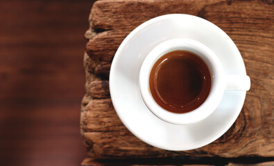 A cup of espresso on the old wooden table in the morning.