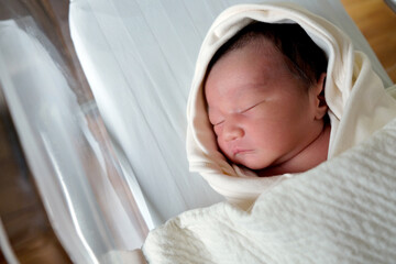 beautiful new born cute infant asleep in the blanket in delivery room