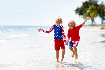 Kids with American flag on beach. 4th of July.