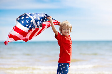 Kids with American flag on beach. 4th of July. - obrazy, fototapety, plakaty
