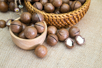 Shelled and unshelled macadamia nuts on wood vintage background