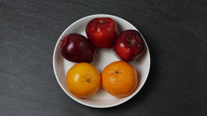 red apples and oranges in a bowl