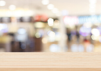 Empty brown wood table top on blur abstract background from inside shopping mall, Used for display or montage your products.