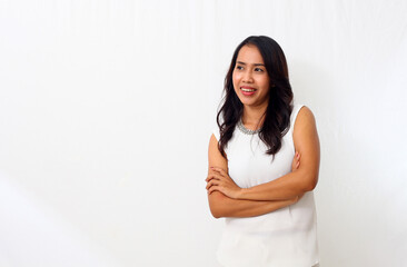 The beautiful young Asian girl smiled as she folded her arms and looking at blank space. Isolated on white background