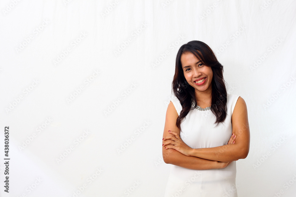 Wall mural the beautiful young asian girl smiled as she folded her arms and looked at camera. isolated on white