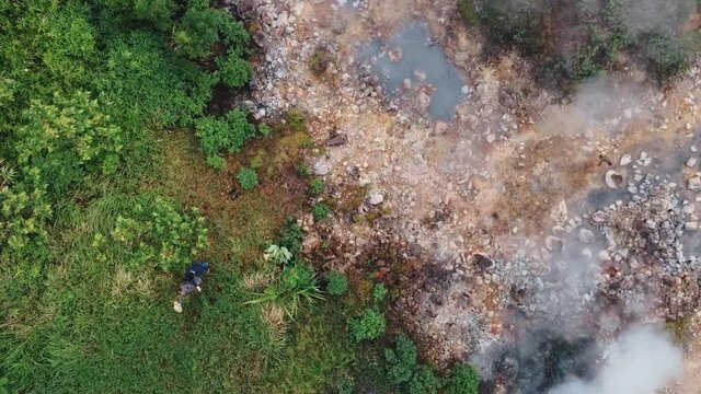 Young couple enjoying nature. Aerial high angle view of jungle and boiling lake Nag Aso, Manito Albay, Philippines