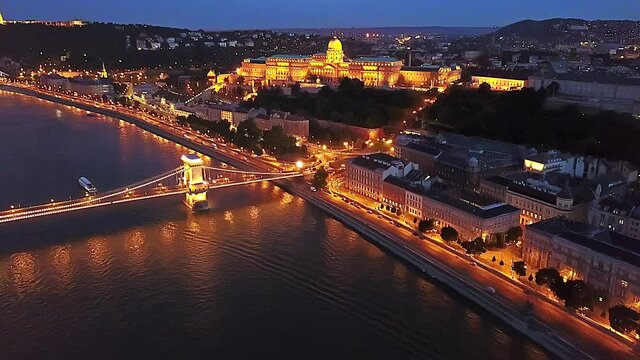 Cinematic 4K aerial drone night dolly video of Castle Hill, Buda Castle, Gell&eacute;rt Hill and the Citadella fortress with the Danube river, bridges illuminated after sunset in Budapest, Hungary