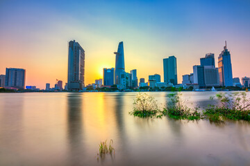 Fototapeta na wymiar Riverside city sunset moments in the sky at end of day brighter coal sparkling skyscrapers along beautiful river in Ho Chi Minh City, Vietnam