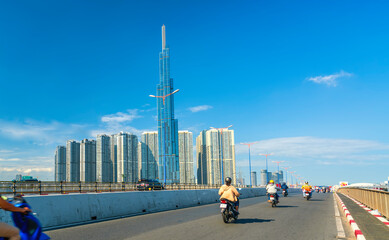 Traffic on the bridge next to the riverside high-rise urban area represents prosperous economic development in dynamic Ho Chi Minh city, Vietnam