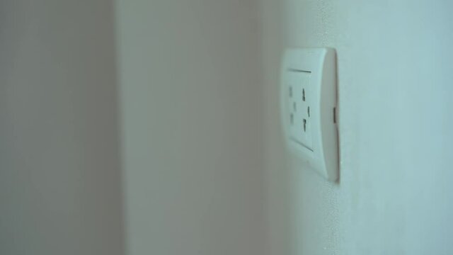 Woman unplugged a smartphone device charger from the plug socket.
