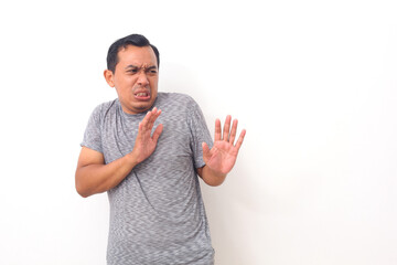 Asian man with disgusted expression repulsing something. Disgust concept. Emotional man. Human emotions, facial expression concept. Isolated on white background