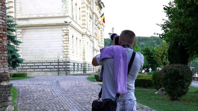 Young man taking photo with digital camera in the city