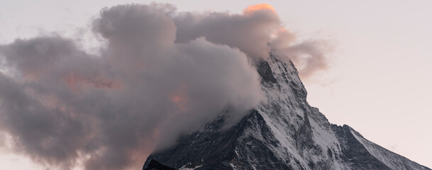 Matterhorn in the Swiss Alps at sunset shrouded in clouds - banner