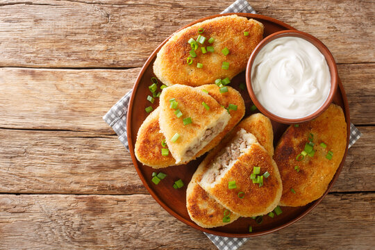 Traditional Ukrainian cuisine tasty Potato zrazy with meat close-up in a plate on the table. Horizontal top view from above