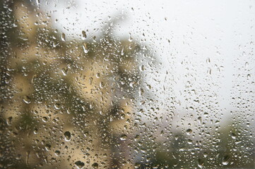 View through window with water drops at rainy weather