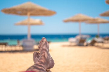 Vacation Concept. man's Bare Feet over Sea background. Vacation holidays relaxing concept. feet on...